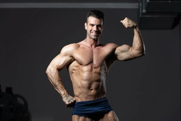 Fisicoculturista modelo de fitness posando bíceps después de ejercicios — Foto de Stock