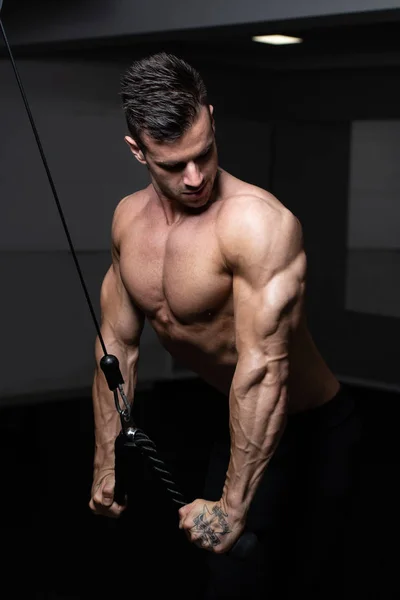 Bodybuilder doen zware oefening voor de Triceps met kabel — Stockfoto