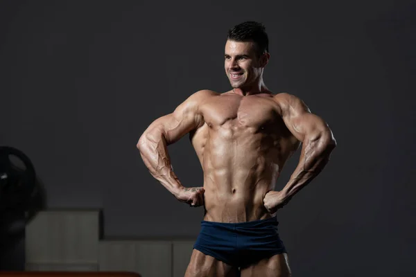 Jonge bodybuilder buigen spieren — Stockfoto