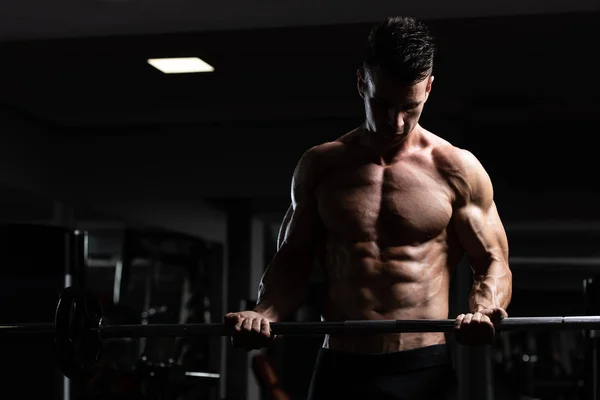 Człowiek na siłowni, ćwiczenia bicepsów z brzana — Zdjęcie stockowe
