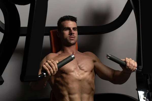 Bodybuilder trainiert Brust an Maschine — Stockfoto