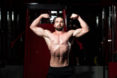 Spor salonunda genç bir adamın pazı poz