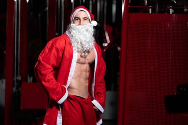 Spor salonunda Santa Claus şapka giyen kaslı adam