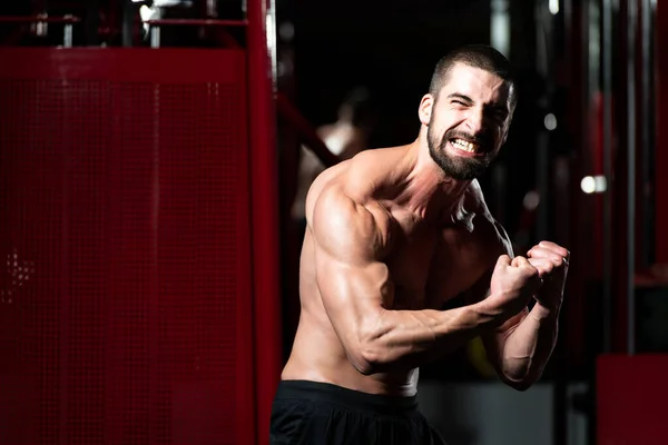 Hombre joven saludable Flexing Músculos —  Fotos de Stock