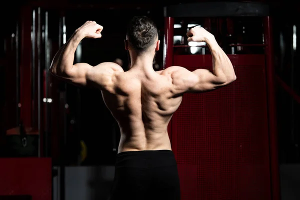Bodybuilder Performing Rear Double Biceps Pose — Stock Photo, Image