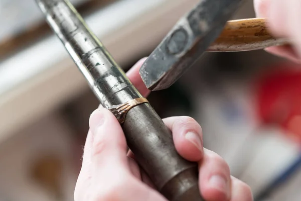 Goldsmith werken aan onvoltooide ring met zijn hamer — Stockfoto