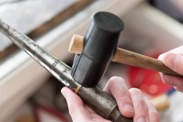 Goldsmith trabalhando em anel inacabado com seu martelo — Fotografia de Stock