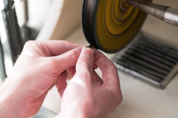 Gros plan du fabricant de bijoux à main utilisant une machine à polir — Photo