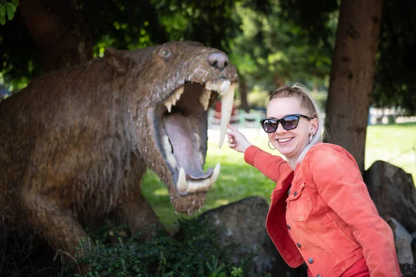 Młoda Ładna Blondynka Czerwonej Kurtce Okularach Stojąc Przy Śmierci Dinozaury — Zdjęcie stockowe