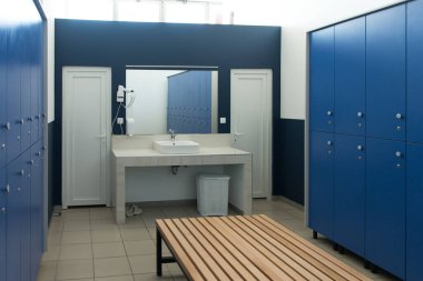 Spor salonundaki mavi soyunma odasının modern iç mekanı.
