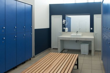 Spor salonundaki mavi soyunma odasının modern iç mekanı.