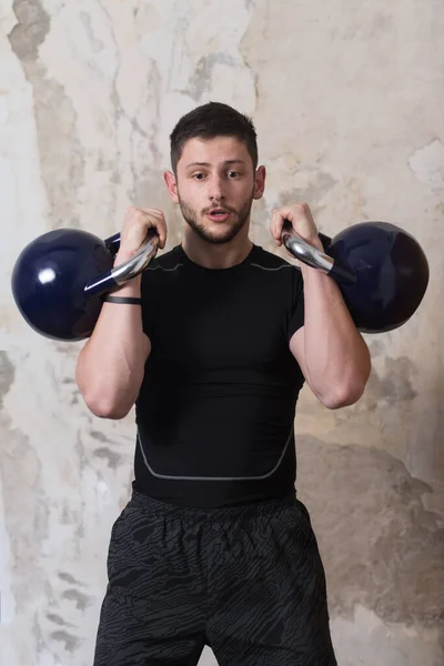 ケトルベルとフレッシング筋肉を持つ男の運動 筋肉運動体ビルダーフィットネスモデルの演習 — ストック写真