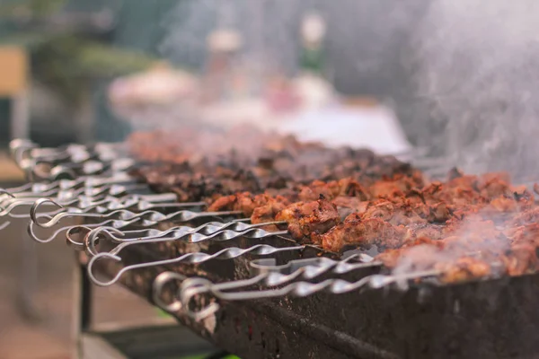 Szaszłyk lub szyszłyk przygotowujący się na grillu nad węglem drzewnym. Grillowane kostki mięsa wieprzowego na metalowym szpikulcu. Na zewnątrz. — Zdjęcie stockowe