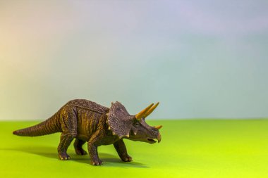 Oyuncak dinozor bir oyuncak ormanda. parlak studio zemin ahşap ağaçları ile gerçek bir dino gibi. Eko oyuncaklar.