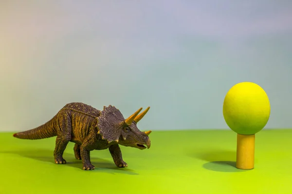 Dinosaure jouet dans une forêt de jouets. comme un vrai dino sur un fond lumineux de studio avec des arbres en bois. Eco jouets . — Photo
