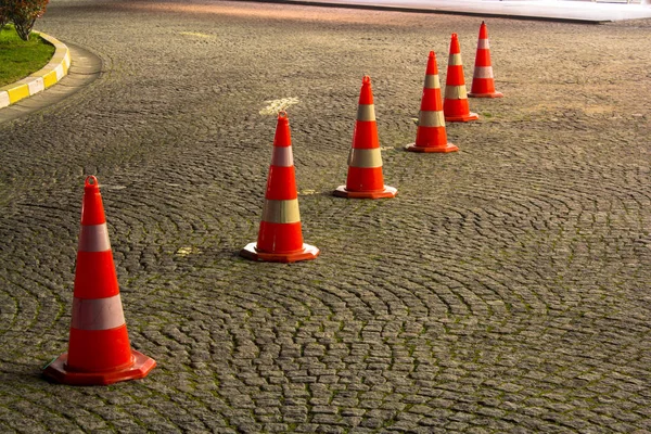 Road cones on the pavement before entering somewhere