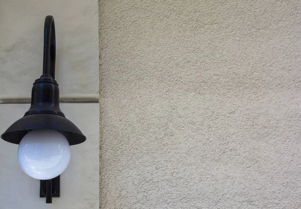 Lâmpada de parede preta com uma lâmpada branca redonda. Lanterna e parede áspera vazia. Modelo de projeto . — Fotografia de Stock