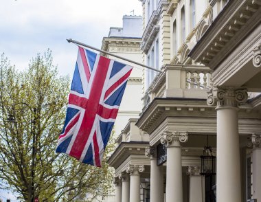 Brexit bahar gününde İngiliz bayrağı sallanıyor. Kensington Caddesi'nde Londra mimarisi.