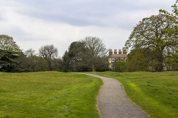 The trail in Greenwich Park, Path among green meadows and trees. Estate in the depths of the park.