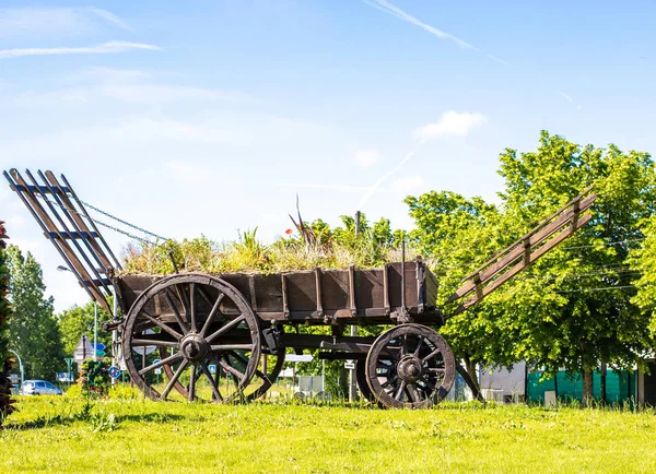 Carrello rustico. Carro fieno vintage in legno. Monumento in un villaggio moderno . — Foto Stock