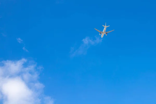 Avión en el cielo azul. El avión está ganando altitud. Nube blanca en el cielo azul en el que vuela el avión . Fotos De Stock