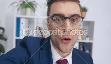 office, gösterilen gözlük el hareketi ve video aramasý sýrasýnda video gülümseyen yakışıklı işadamı