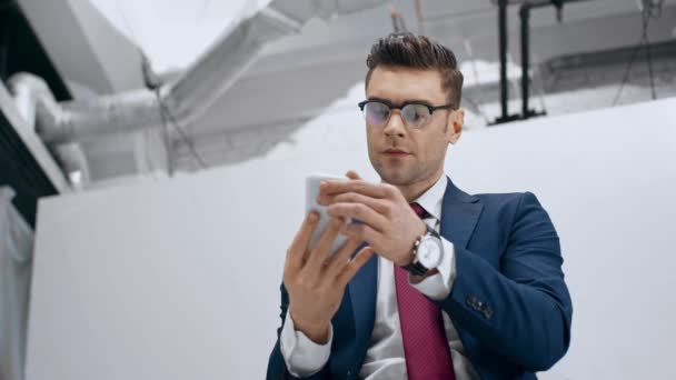 Schöner Geschäftsmann Lächelt Und Rührt Krawatte Während Selfie Mit Smartphone — Stockvideo