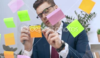 yakışıklı, özenli işadamı üzerine yapışkan notlar yazma