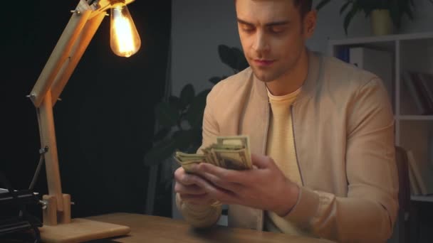 Homem Negócios Sorrindo Contando Notas Dólar Enquanto Sentado Mesa Trabalho — Vídeo de Stock