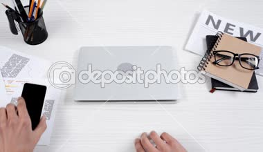 dizüstü açılış ve gözlüklerini koyarak smartphone masanın üzerine koyarak işadamı kısmi görünümü