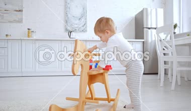 geniş dairede sallanan at plastik yapı taşları ile oynayan sevimli Toddler çocuk