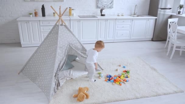 Menino Criança Brincando Com Bola Espaçoso Apartamento Branco Com Brinquedos — Vídeo de Stock