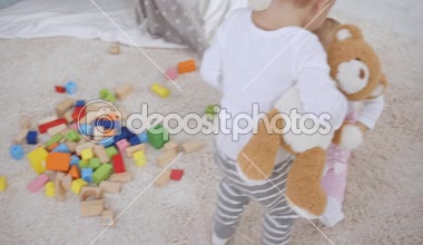 bebek kardeşi halı üzerinde oturuyor ve küpler ile oynarken, ahşap bloklar toplayan Toddler çocuk