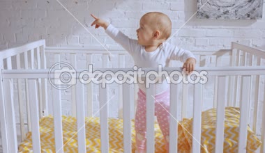 bebek beşik ve etrafında parmak ile işaret şirin çocuk ayakta gülümseyen