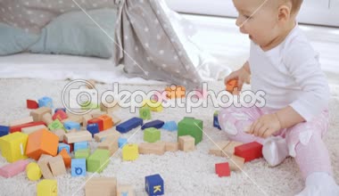 sevimli Toddler çocuk halı üzerinde çok renkli ahşap bloklar ile oynuyor 