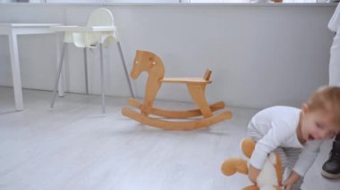 dairede oyuncak ayı ile çalışan sevimli Toddler çocuk ve sonra halı üzerinde topu ile oynuyor
