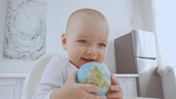 Усміхнена Мила Дитина Сидить Високому Кріслі Грає Іграшковим Глобусом — стокове відео