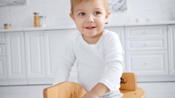 かわいい幼児少年は家で木製のロッキングホースに乗って笑う — ストック動画