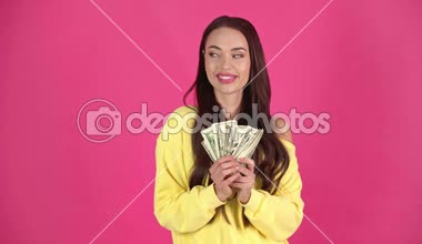 Stüdyo Doları banknot tutan çekici mutlu genç kadın ateş