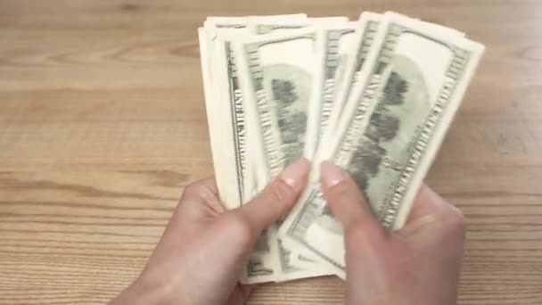 コピースペースを持つ木製のテーブルでドル紙幣を数える女性のクロップビュー — ストック動画