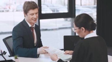 neşeli adam devam veren, gülümseyen, ayakta ve ofiste işkadını ile el sallayarak 