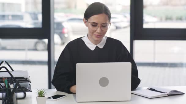 Ελκυστική Επιχειρηματίας Κοιτάζοντας Laptop Χαμογελώντας Και Γράφοντας Στο Σημειωματάριο Στο — Αρχείο Βίντεο