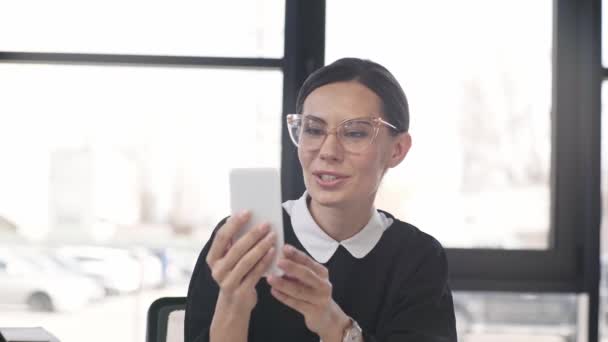 Vrolijke Vrouw Glazen Die Smartphone Terwijl Het Hebben Van Videopraatje — Stockvideo