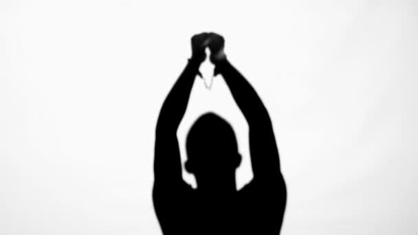 手を振って 白い上に孤立した手錠を脱ぐ男のシルエット — ストック動画