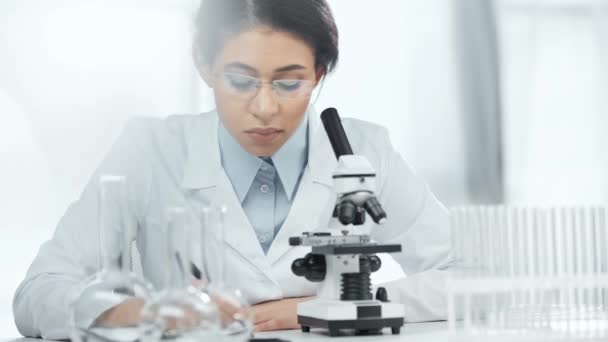 African American Scientist Glasses Writing Clipboard While Looking Sample Microscope — Stock Video