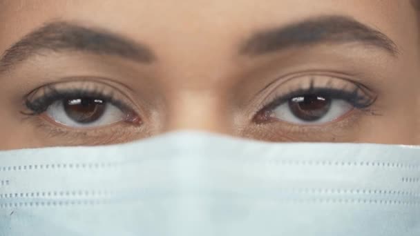 特写的非洲美国妇女在医疗面具闪烁 而看着相机 — 图库视频影像