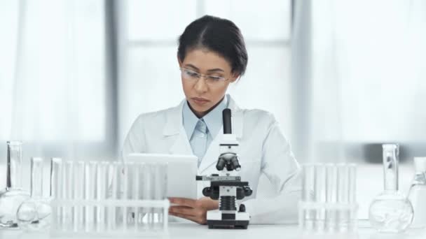 African American Scientist Using Digital Tablet Looking Glass Flasks Using — Stock Video