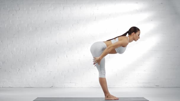 Side view of woman taking deep breath, practicing uttanasana, doing plank, practicing adho mukha svanasana, stretching and looking at camera — Stock Footage Side View Woman Taking Deep Breath Practicing Uttanasana Doing Plank Video Clip