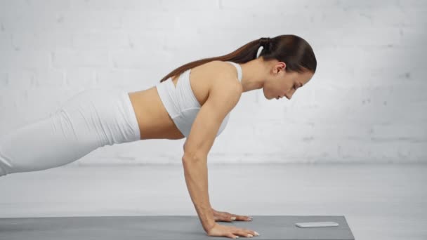 Frau Macht Liegestütze Und Scrollt Smartphone Bildschirm Auf Yogamatte — Stockvideo