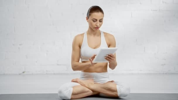Mujer Enfocada Sentada Pose Loto Usando Tableta Digital Sonriendo Meditando — Vídeo de stock